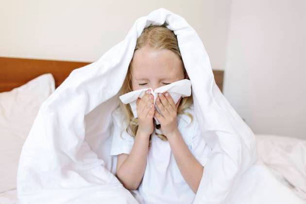 Girl blowing nose with tissue at home model released, Symbolfoto, SIF00156