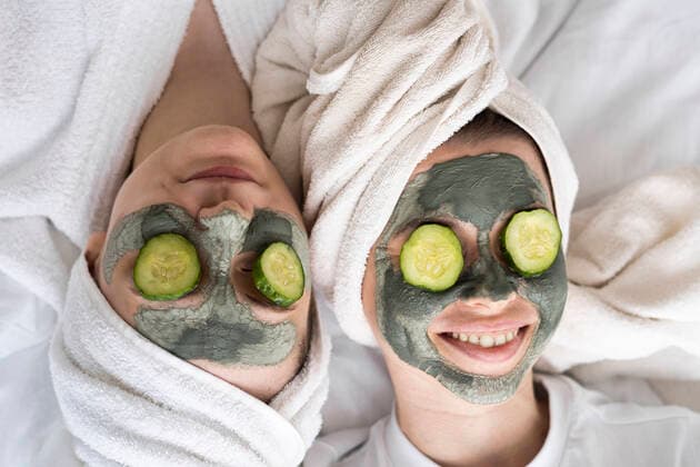 Happy friends wearing facial masks relaxing on bed at home model released, Symbolfoto property released, SSGF00945