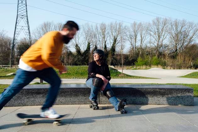 Mature man skating by friend sitting in park model released, Symbolfoto, ASGF02302