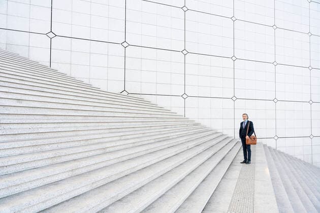 Creative Highlights Symbolbilder Mature businessman with bag standing on steps model released, Symbolfoto, OIPF01933