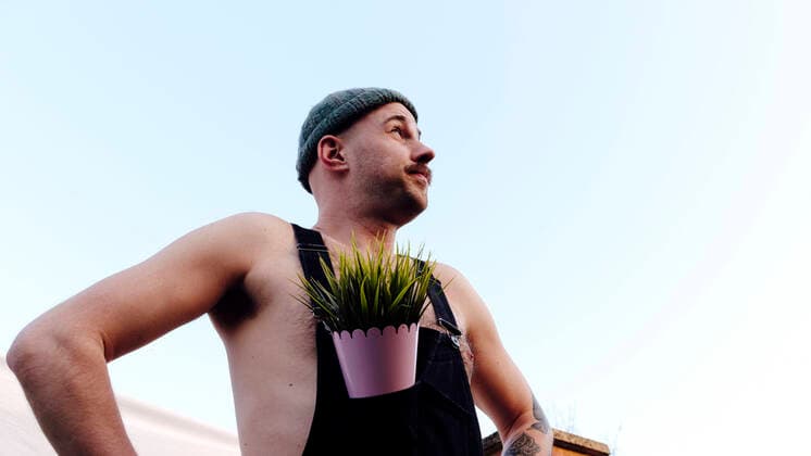 Creative Highlights Symbolbilder Man wearing knit hat standing with plant in bib overalls model released, Symbolfoto property released, ASGF02416