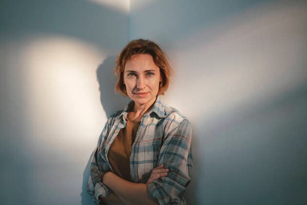 Creative Highlights Symbolbilder Smiling woman with arms crossed standing in front of wall model released, Symbolfoto property released, JOSEF10449