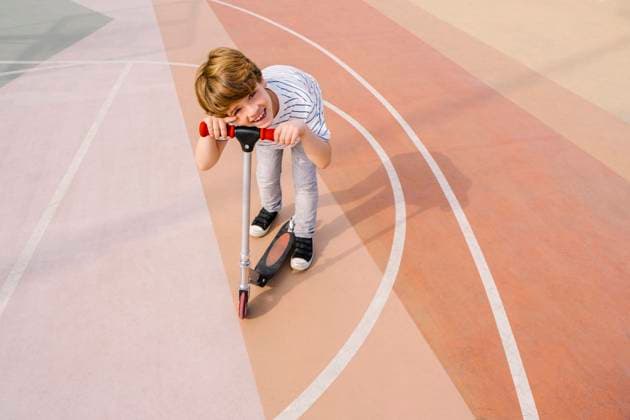 IMAGO Creative: 2022 Sport Favoriten Creative Highlights Symbolbilder Smiling boy with push scooter at sports court model released, Symbolfoto, MMPF00117
