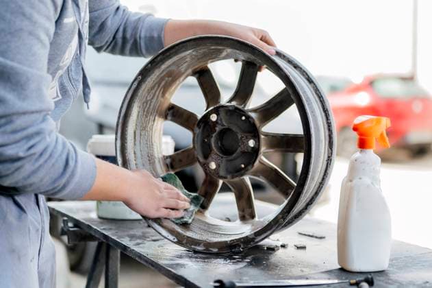 Hands of mechanic cleaning wheel in workshop model released, Symbolfoto property released, PGF01083