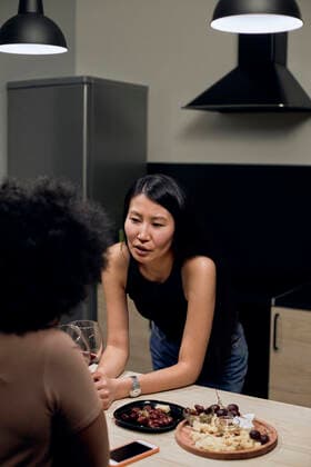 IMAGO Creative, Food, Tapas Young woman talking with girlfriend in kitchen at home model released, Symbolfoto property released, DSHF00484
