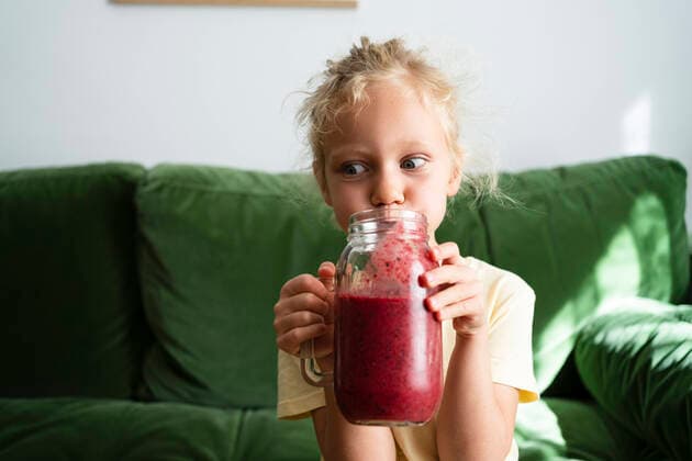 Creative Highlights Symbolbilder Girl drinking homemade strawberry smoothie in living room model released, Symbolfoto property released, SVKF00257