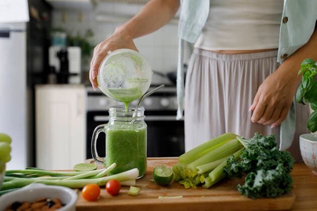 Hand of woman pouring smoothie in mason jar from juicer at home model released, Symbolfoto property released, TYF00186