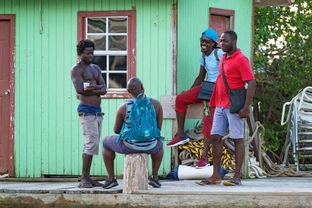 Local black men gathering at the colourful wooden docks in Marigot Bay on the island of Saint Lucia in the Caribbean Sea Arterrax xMaricaxvanxderxMeer 1012_19_211018p051
