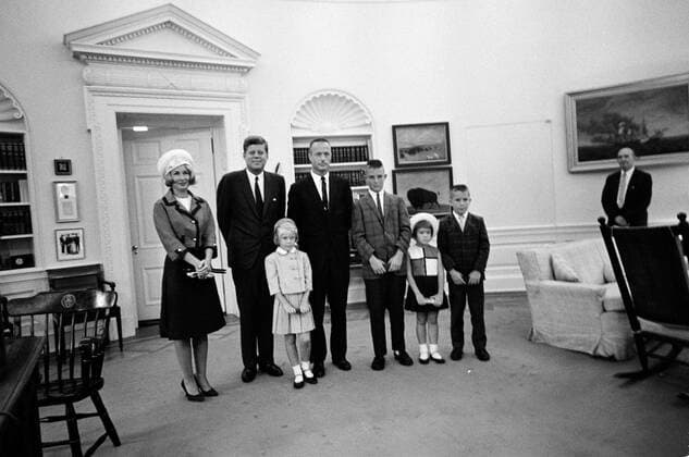 Visit of Astronaut Lt. Cmdr. Scott Carpenter family, 10:00AM. President John F. Kennedy stands with astronaut Lieutenant Commander M. Scott Carpenter and his family, during their visit to the White House following Lt. Cdr. Carpenters Mercury-Atlas 7 orbital flight (also known as Aurora 7). Left to right: Rene Carpenter, President Kennedy, Kristen Elaine Carpenter, Lt. Cdr. Carpenter, Marc Scott Carpenter, Candace Noxon Carpenter, and Robyn Jay Carpenter. Special Assistant to the President, Dave Powers, stands in background at right. Oval Office, White House, Washington, D.C. Copyright: xpiemagsx