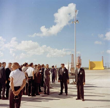 Inspection tour of NASA installations: Cape Canaveral Florida, 2:31PM. President John F. Kennedy (center left, wearing sunglasses) looks up at a Saturn rocket launch site under construction at Launch Complex 37, during a tour of Cape Canaveral Air Force Station, Cape Canaveral, Florida. Also pictured: Assistant Press Secretary, Malcolm Kilduff; White House Secret Service agents, Joe Paolella, Jack Ready, and Emory Roberts. President Kennedy visited Cape Canaveral as part of a two-day inspection tour of National Aeronautics and Space Administration (NASA) field installations. Copyright: xpiemagsx