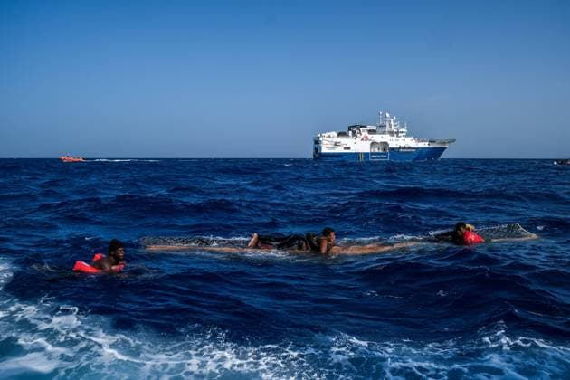 Refugees are being carried by a piece of wood from an inflatable boat that seems to have broken into several pieces. They call for help from the humanitarian team that has come to rescue them. The humanitarian team is part of the NGO boat, Medecin Sans Frontieres, which helps people trying to cross the Mediterranean to reach the European continent from Libya. 27 June 2022.  MichaelxBunelx xLexPictorium LePictorium_0264728