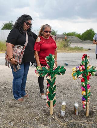June 28, 2022, San Antonio, Texas, USA: Debra Ponce, left, and Angelita Olvera pray after setting up two crosses on Tuesday, the day after as many as 50 migrants died as a result of heat in a trailer at Quintana Road and Cassin in San Antonio. San Antonio USA  - ZUMAa27_ 20220628_znn_a27_009 Copyright: xSanxAntonioxExpress-Newsx
