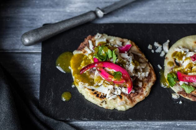 From above delicious traditional Yucatan panuchos with chicken and beans garnished with green sauce and pickled red onion and served on black slate AlexSalcedo_MexicanFood_08.jpg Copyright: xAlexxSalcedox Model Released