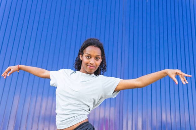 Creative Highlights Symbolbilder From below female dancer standing next to on blue wall with outstretched arms, Model released DavidMunoz_CarlaAndNicoleFiraDance_31.jpg Copyright: xDavidxMunozx MR
