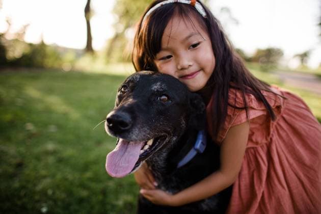 Creative Highlights Symbolbilder Six Year Old Asian Girl Hugging Black Lab at Park in San Diego San Diego, California, United States CR_JIDE220630-991290-01 ,model released, Symbolfoto