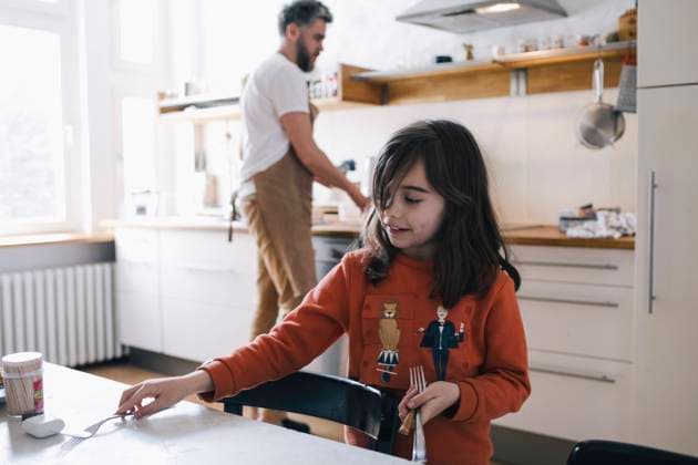 IMAGO Creative: 2022 Favoriten IMAGO Creative: Menschen in Berlin - Generationen Girl arranging fork on dinging table while father doing chores in kitchen Berlin, Germany, model released, property released Copyright: xMaskotx , MA93009 MA93009