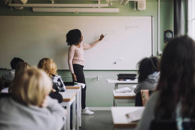 Side view of teacher explaining mathematics to students on white board in classroom Sweden, Stockholm, model released, property released Copyright: xMaskotx , MA93431 MA93431