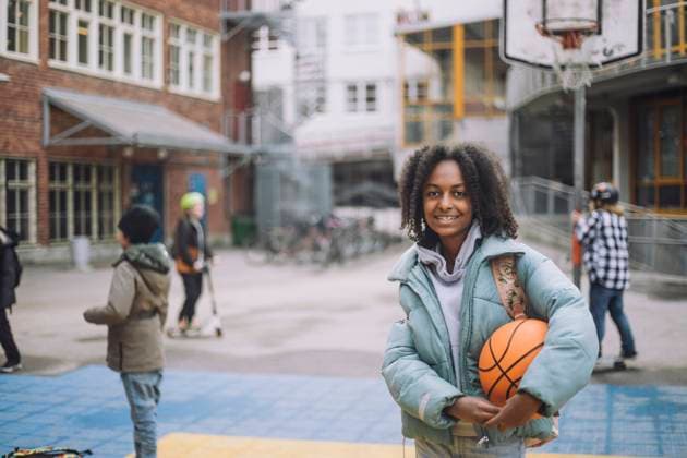 IMAGO Creative: Lokalhelden - Jugendsportbildung Portrait of smiling girl with basketball standing in sports court at school campus Sweden, Stockholm, model released, property released Copyright: xMaskotx , MA93460 MA93460