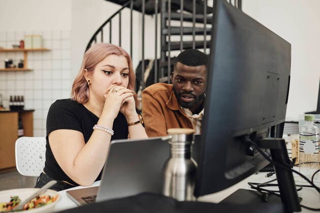 Male and female computer programmers looking at laptop in office Sweden, Stockholm, model released, property released Copyright: xMaskotx , MA94263 MA94263