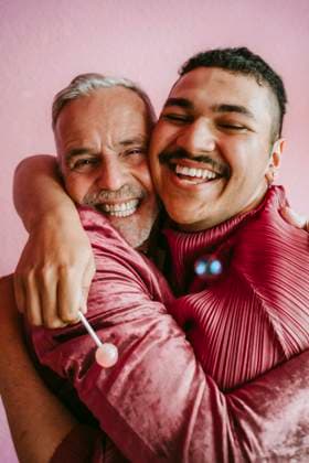 IMAGO Creative: 2022 Favoriten Happy gay friends embracing each other against wall at home Germany, Berlin, model released, property released Copyright: xMaskotx , MA94391 MA94391