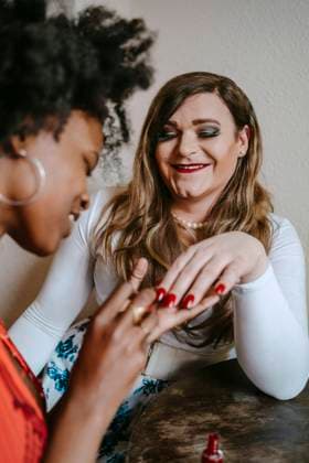 Young woman applying nail polish to non-binary friend at home Germany, Berlin, model released, property released Copyright: xMaskotx , MA94397 MA94397
