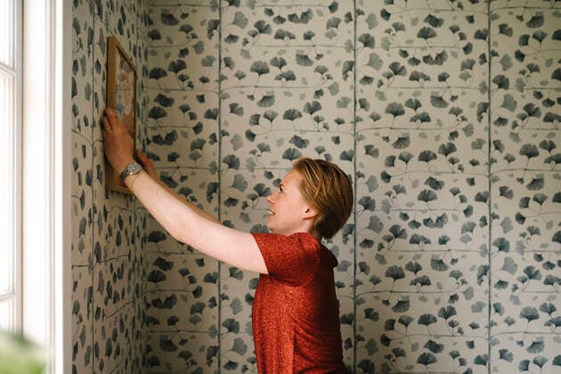 IMAGO Creative: Neue Aussichten Side view of woman adjusting picture frame on wall at home Sweden, Gothenburg, model released, property released Copyright: xMaskotx , MA94469 MA94469