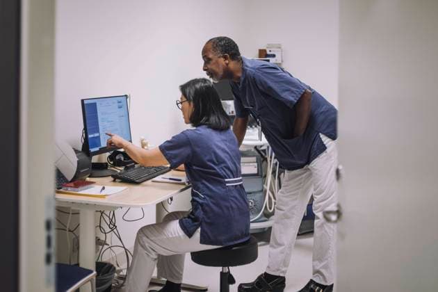 Female doctor pointing at computer monitor while discussing with male colleague in hospital Sweden, Stockholm, model released, property released Copyright: xMaskotx , MA94525 MA94525