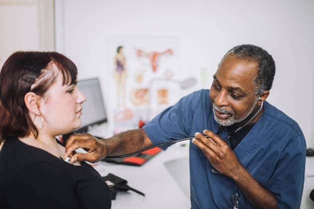 Male healthcare expert with stethoscope examining female patient in clinic Sweden, Stockholm, model released, property released Copyright: xMaskotx , MA94572 MA94572