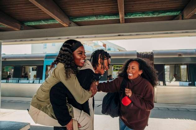 Creative Highlights Symbolbilder Happy woman standing by man piggybacking female friend at railroad station platform Sweden, Stockholm, model released Copyright: xMaskotx , MA94649 MA94649