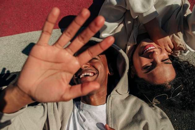 IMAGO Creative: 2022 Favoriten Creative Highlights Symbolbilder Cheerful man showing palm while lying by female friend in playground Sweden, Stockholm, model released Copyright: xMaskotx , MA94697 MA94697