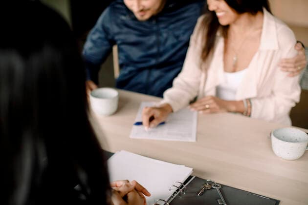 Real estate agent with couple signing contract at table in new house Sweden, Stockholm, model released, property released Copyright: xMaskotx , MA94735 MA94735