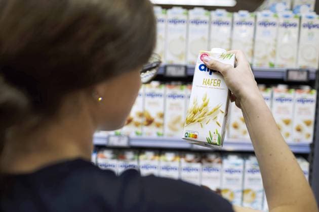 Junge Frau kauft im Supermakt Hafermilch ein. copyright: Ute Grabowsky photothek Radevormwald Deutschland *** Young woman buying oat milk in supermarket copyright Ute Grabowsky photothek Radevormwald Germany Copyright: xUtexGrabowsky photothek.dex