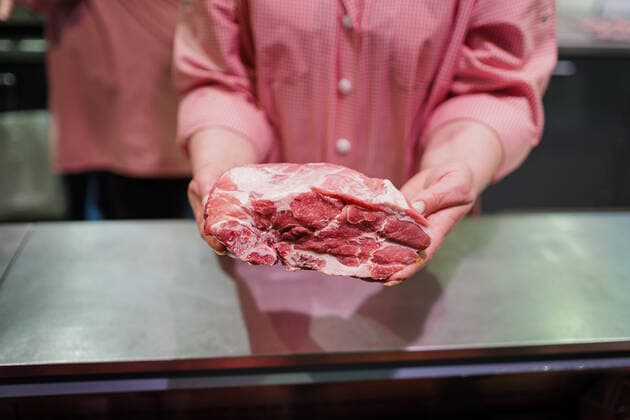 Stueck Schweinenacken fuer Steaks beim Metzger im Supermakt. Radevormwald Deutschland *** Piece of pork neck for steaks at the butcher in supermarket Radevormwald Germany Copyright: xUtexGrabowsky photothek.dex
