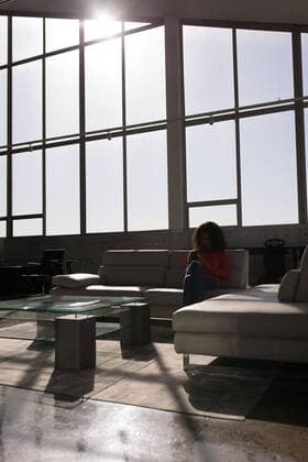 IMAGO Creative: Internationaler Tag der Architektur am 3. Oktober. Thema: Architektur zum Wohlfühlen Female executive using mobile phone in office Front view of young mixed race female executive using mobile phone while relaxing on couch in modern office, model released, , property released, Cork, Ireland, 22.01.2019, 1231126.jpg, smartphone, mobile phone, cellphone, phone, wireless technology, communication, global communication, connection, holding, screen, sitting, looking, relax, relaxing, rest, office, workplace, glass, interior, modern, architecture, urban, sofa, casual clothing, millennial, professional, business, businesswoman, colleagues, executive, associate, occupation, profession, skill, expertise, entrepreneur, corporate, company, innovation, strategy, planning, career, creative, smart, elegant, luxury, lifestyle, start up bu
