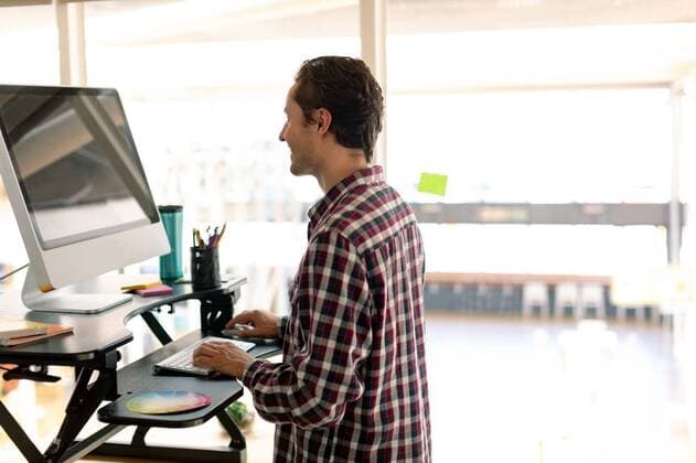 Male graphic designer working on computer at desk Side view of Caucasian male graphic designer working on computer at desk in office, model released, , property released, Cape Town, South Africa, 16.03.2019, 1260568.jpg, millennial, smart, handsome, smart casual, business, businessman, graphic designer, designer, artist, executive, associate, occupation, profession, professional, skill, expertise, entrepreneur, corporate, company, office, workplace, desk, color swatch, penholder, computer stand, water bottle, standing, working, computer, desktop pc, personal computer, keyboard, technology, communication, connection, modern, leisure, lifestyle, caucasian ethnicity Young Adult,Man,Male,Caucasian Indoors,Side view,Half length