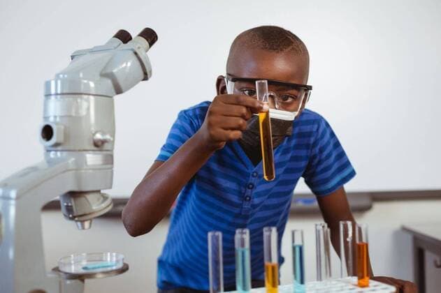 IMAGO Creative: Bildung, Wissenschaftserziehung African american schoolboy in safety glasses and face mask looking at test tubes in science class African american schoolboy in safety glasses and face mask looking at test tubes in science class. childhood and education at elementary school during coronavirus covid19 pandemic., model released, , property released, Cape Town, South Africa, 17.04.2021, 1449212.jpg, people,african american,schoolboy,safety,glass,face mask,looking,test tube,science,class,childhood education,elementary school,coronavirus,covid,pandemic,epidemic,virus,quarantine,infection,corona,flu,disease,outbreak,prevention,mask,ncov,protection,medical,illness,protective,medicine,influenza,respiratory,pneumonia,vaccine,african,american,face,test,tube,childhood,education,elem