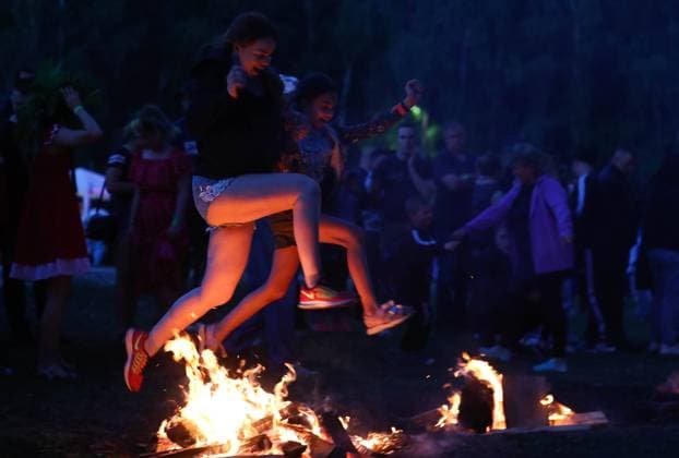 KEMEROVO REGION, RUSSIA - JULY 8, 2022: Girls jump over a bonfire during Ivan Kupala Day celebrations at the Tomskaya Pisanitsa open-air museum in Kemerovo Region s Yashkinsky District, some 50 km northwest of Kemerovo. Maxim Kiselev TASS  TS1397A1