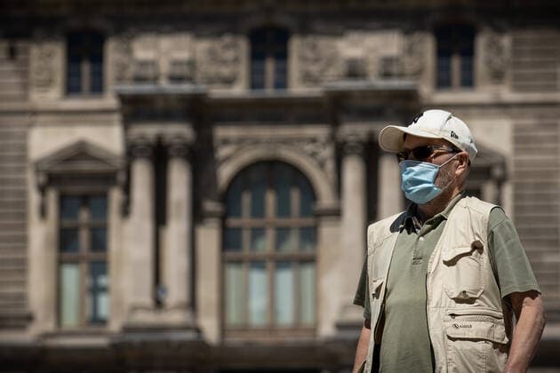 (220709) -- PARIS, July 9, 2022 -- A man wearing a face mask walks in front of the Louvre Museum in Paris, France, July 8, 2022. The total number of COVID-19 related deaths in France passed the 150,000 mark on Friday, after 74 deaths related to the virus were recorded in hospitals in the past 24 hours, announced the country s public health agency. (Photo by Xinhua) FRANCE-PARIS-COVID-19-DEATH AurelienxMorissard 
