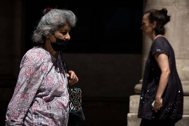 (220709) -- PARIS, July 9, 2022 -- A woman wearing a face mask walks on a street in Paris, France, July 8, 2022. The total number of COVID-19 related deaths in France passed the 150,000 mark on Friday, after 74 deaths related to the virus were recorded in hospitals in the past 24 hours, announced the country s public health agency. (Photo by Xinhua) FRANCE-PARIS-COVID-19-DEATH AurelienxMorissard 