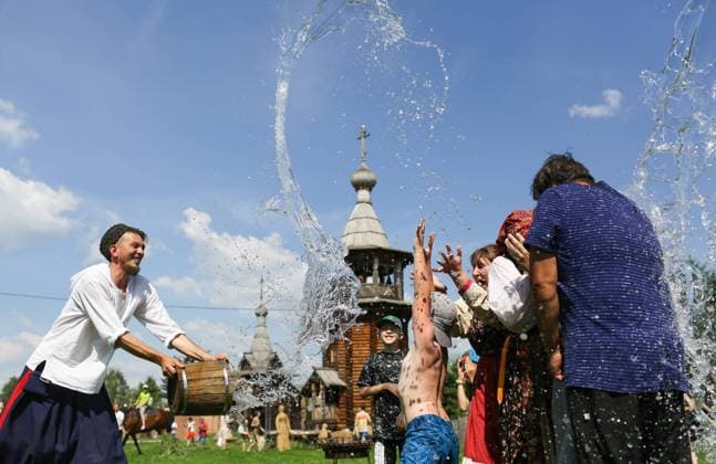 OMSK REGION, RUSSIA â€“ JULY 10, 2022: Pouring water on people during festivities marking Ivan Kupala Day, a pagan summer solstice celebration, at the Starina Sibirskaya local history and culture open air museum in the village of Bolsherechye. Yevgeny Sofiychuk TASS  TS139B54