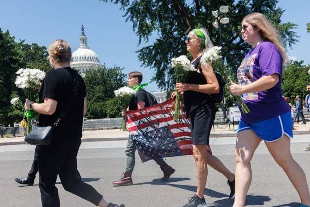 Abortion Rights Vigil Outside Supreme Court Demonstrators attend a vigil hosted by NextGen America in Washington, D.C. on July 11, 2022, wearing all black and laying Chrysanthemum flowers on a fence outside of the Supreme Court to symbolize and honor the number of people they estimate to lose their lives as a direct result of the overturning of Roe v. Wade. Washington, D.C. D.C. United States  Copyright: xBryanxOlinxDozierx originalFilename: dozier-abortion220711_npUS4.jpg