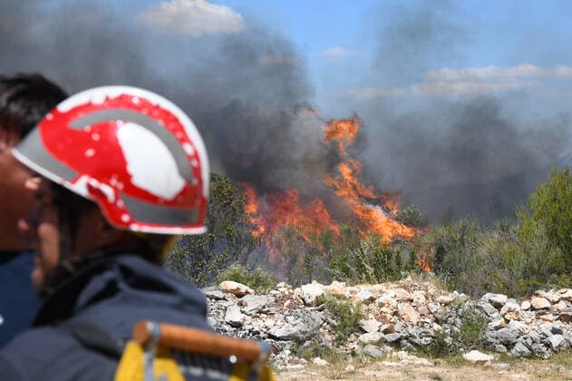 PXL_A fire near Vodice, Croatia Fire in an open area near the Velika Mrdakovica archaeological site in the Vodice hinterland, Croatia on July 13, 2022. About 30 firefighters with a dozen vehicles are on the ground, and two Canadairs joined the ground forces in extinguishing the fire. There are pine forests above, low vegetation, and endangered buildings. HrvojexJelavic PIXSELL