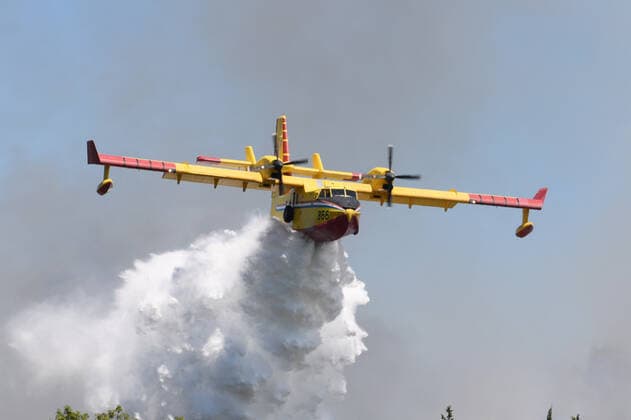 PXL_A fire near Vodice, Croatia Fire in an open area near the Velika Mrdakovica archaeological site in the Vodice hinterland, Croatia on July 13, 2022. About 30 firefighters with a dozen vehicles are on the ground, and two Canadairs joined the ground forces in extinguishing the fire. There are pine forests above, low vegetation, and endangered buildings. HrvojexJelavic PIXSELL