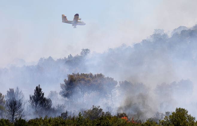 PXL_A fire near Vodice, Croatia Fire in an open area near the Velika Mrdakovica archaeological site in the Vodice hinterland, Croatia on July 13, 2022. About 30 firefighters with a dozen vehicles are on the ground, and two Canadairs joined the ground forces in extinguishing the fire. There are pine forests above, low vegetation, and endangered buildings. DuskoxJaramaz PIXSELL