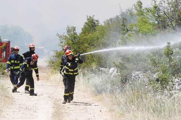 PXL_A fire near Vodice, Croatia Fire in an open area near the Velika Mrdakovica archaeological site in the Vodice hinterland, Croatia on July 13, 2022. About 30 firefighters with a dozen vehicles are on the ground, and two Canadairs joined the ground forces in extinguishing the fire. There are pine forests above, low vegetation, and endangered buildings. HrvojexJelavic PIXSELL