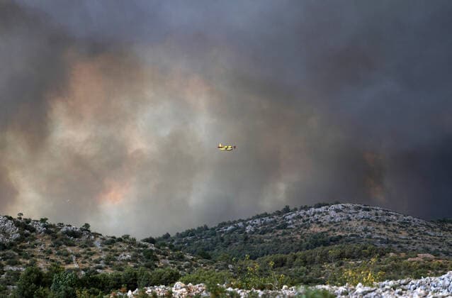 PXL_A fire near Zaton, Croatia Fire in an open area near the Zaton site in the Vodice hinterland, Croatia on July 13, 2022. About 30 firefighters with a dozen vehicles are on the ground, and two Canadairs joined the ground forces in extinguishing the fire. There are pine forests above, low vegetation, and endangered buildings. DuskoxJaramaz PIXSELL