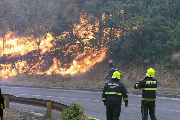 PXL_Zaton fire by the road Fire in an open area near the Zaton site in the Vodice hinterland, Croatia on July 13, 2022. About 30 firefighters with a dozen vehicles are on the ground, and two Canadairs joined the ground forces in extinguishing the fire. There are pine forests above, low vegetation, and endangered buildings. HrvojexJelavic PIXSELL