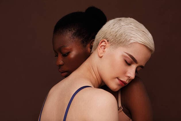 Creative Highlights Symbolbilder Two young women with different skin color standing together. Females put their heads on each other s shoulders with closed eyes. Copyright: xxArtemxVarnitsinx