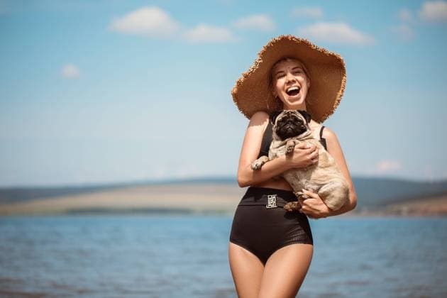 Creative Highlights Symbolbilder Sexy girl in a wide hat with a pug on the beach Baikal (Port), Irkutsk Oblast, Russia CR_DGAA220713-1009554-01 ,model released, Symbolfoto