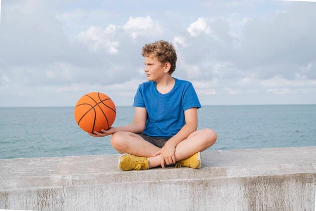 Creative Highlights Symbolbilder Portrait of a boy with a basketball on the sea and sky. Sochi, Krasnodar Krai, Russia CR_OWQV22071354-1010974-01 ,model released, Symbolfoto